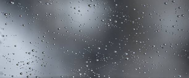 istock Rain water drops on a black dramatic window glass. Autumn bokeh depression background. Rain pattern
