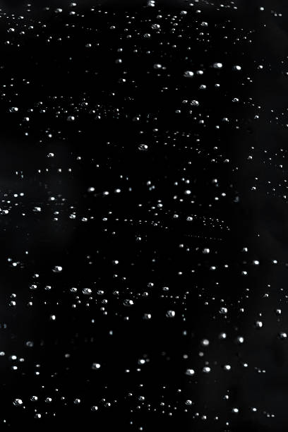 istock Falling Rain water drops on a black dramatic window glass. Autumn  depression background. Rain pattern
