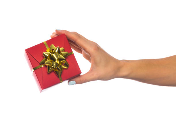 istock female hand holds a beautiful gift box with a bow isolated on white background 1208532890