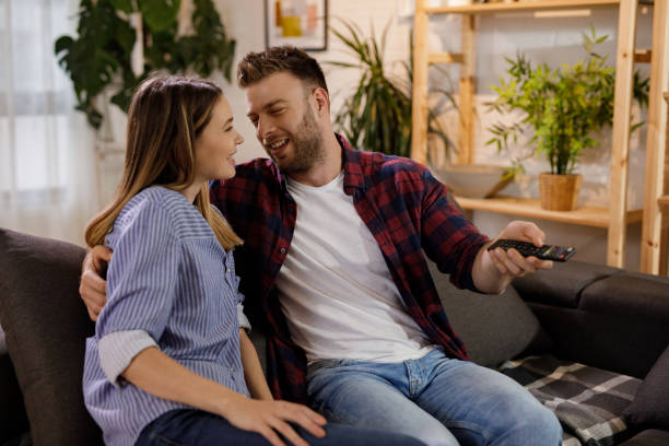istock Young romantic couple at home watching TV 1208533461