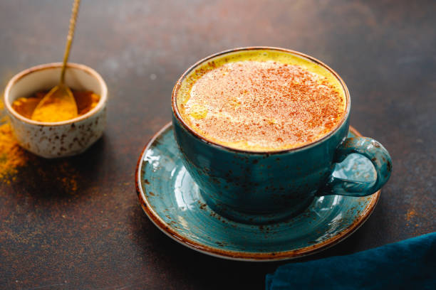 istock Closeup view of turmeric latte cup on a textured dark background. 1208536400