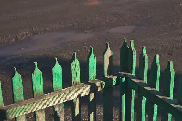 angolo della recinzione picchetto verde vicino alla casa - picket fence grass gardens nature foto e immagini stock