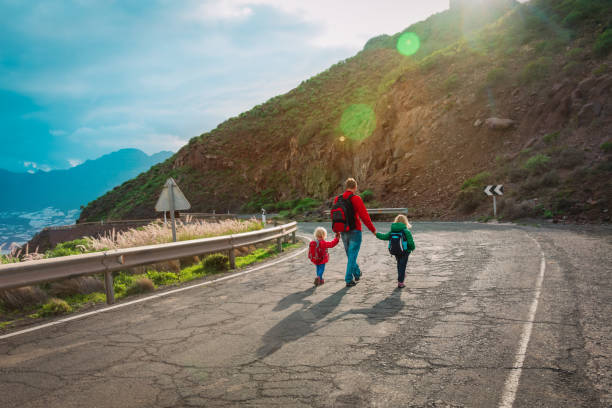 istock father with two kids walking on road in sunset mountains 1208539124