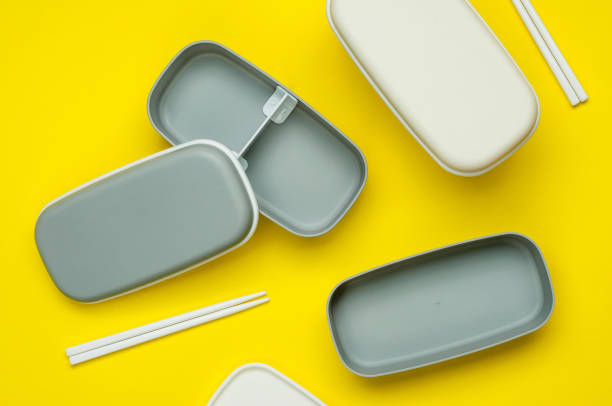 Empty plastic lunch boxes with sticks on yellow background Empty plastic lunch boxes with sticks on yellow background. Top view, flat lay. empty bento box stock pictures, royalty-free photos & images