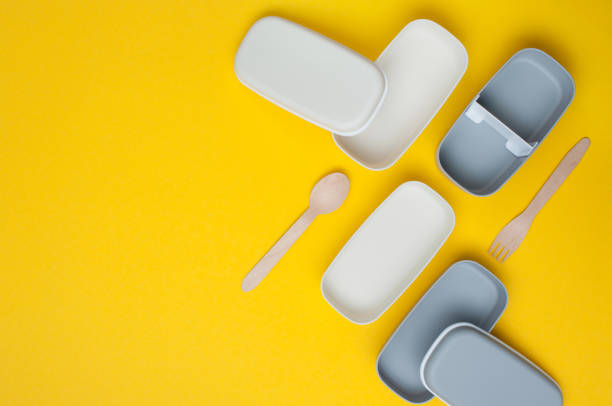 Empty plastic lunch boxes with sticks on yellow background Empty plastic two-layered lunch boxes on yellow background with blank space for text. Top view, flat lay. empty bento box stock pictures, royalty-free photos & images