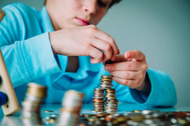 istock child counting money, boy collectiong coins, saving concept 1208539959