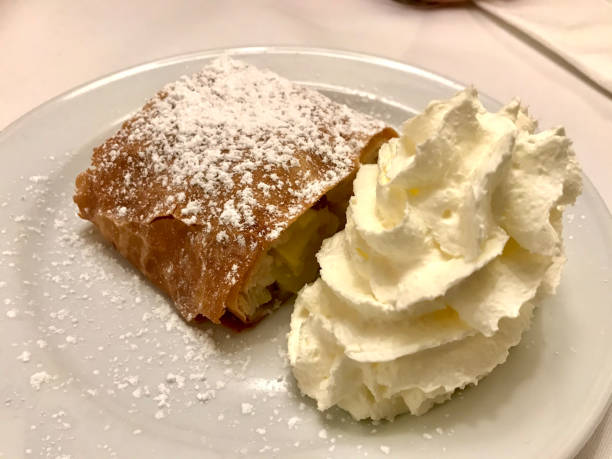 istock Authentic Traditional Apple Strudel, Apfelstrudel in Vienna, Austria. Served on a white plate, in restaurant setting. Vanilla ice cream, powdered sugar and mint leaves on top 1208540116