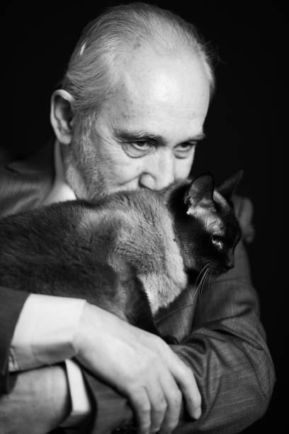 istock Cheerfull senior man with cat isolated 1208541497