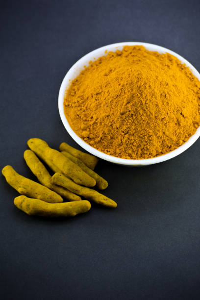 istock Turmeric powder in white bowl with roots or barks 1208542802