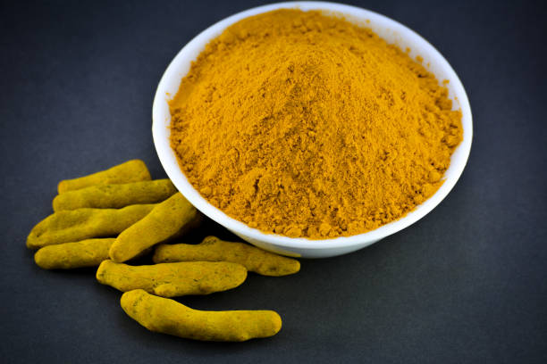 istock Turmeric powder in white bowl with roots or barks 1208542836