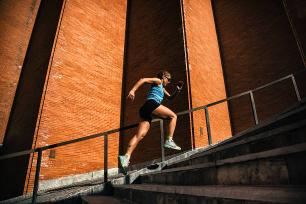 istock Young woman professional athlete doing training on stairs 1208542886