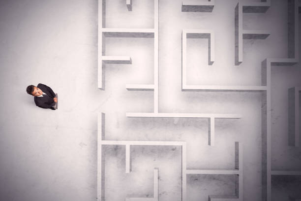 istock Confused businessman standing at a maze wall 1208545432