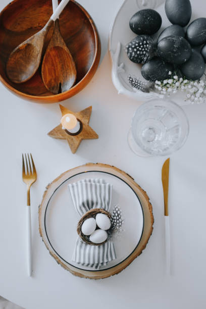 istock Easter table setting with white plate, gray textile napkin, quail and chicken eggs and blossom branch on table. Top view, flatlay 1208545861