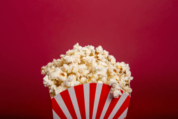 istock Rolled paper bucket with delicious popcorn on red background with space for text. 1208546825