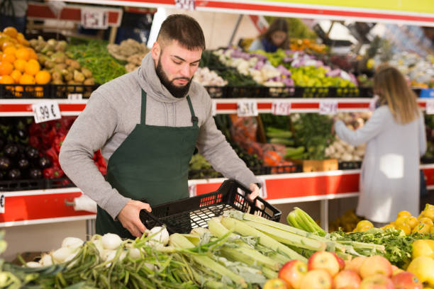 istock Market worker puts vegetables on the counter 1208549182