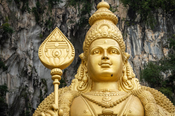 Batu Caves, Malaysia: A detail of the golden Murugan statue in front of the entrance to the Hindu shrines at Batu Caves.