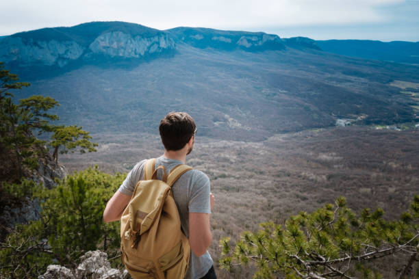 istock young hipster man in the spring mountains 1208551168