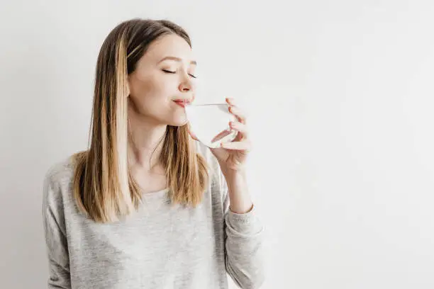 Young woman drinking water and smiling