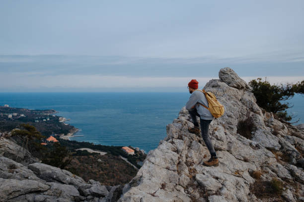 istock Man with backpack hiking and red hat in mountains 1208551823
