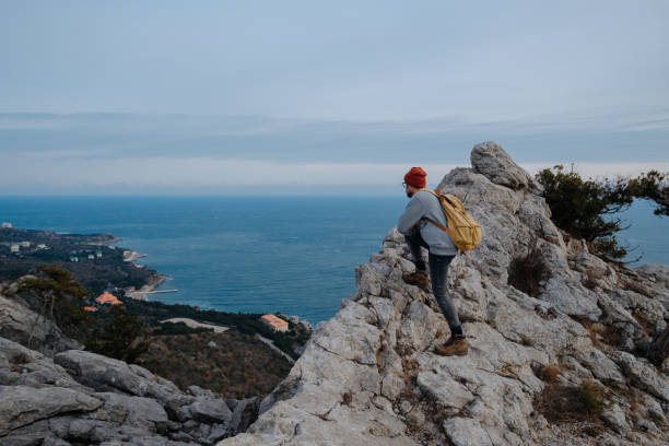 istock Man with backpack hiking and red hat in mountains 1208551856