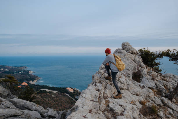 istock Man with backpack hiking and red hat in mountains 1208551857