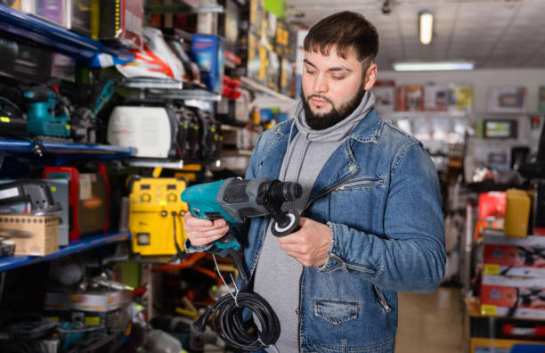 istock Adult man is buying new hammer drill in tools store 1208552003