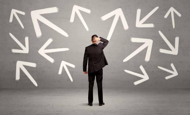 istock Confused salesman with arrows on wall 1208553626