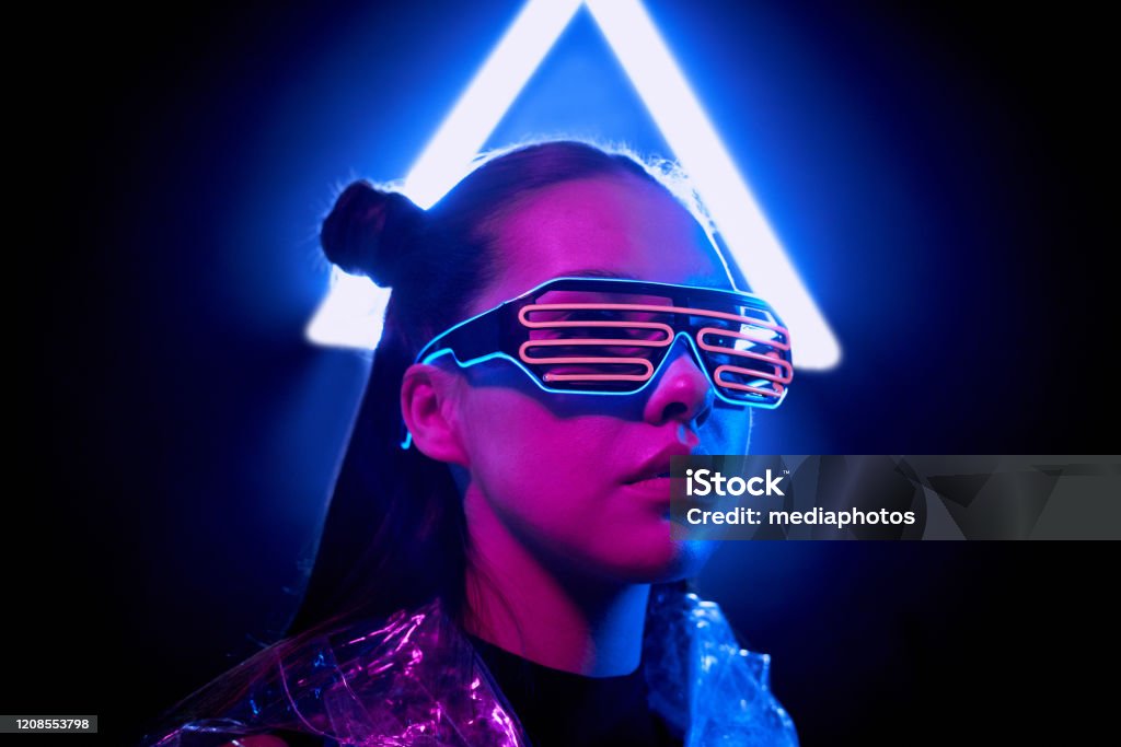 Portrait Of Serious Cyber Woman In Wire Led Glasses Standing In Light Of  Neon Sign Stock Photo - Download Image Now - iStock