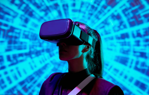 istock Curious girl in VR goggles standing against blue cyclical spinning background and studying around reality 1208554530