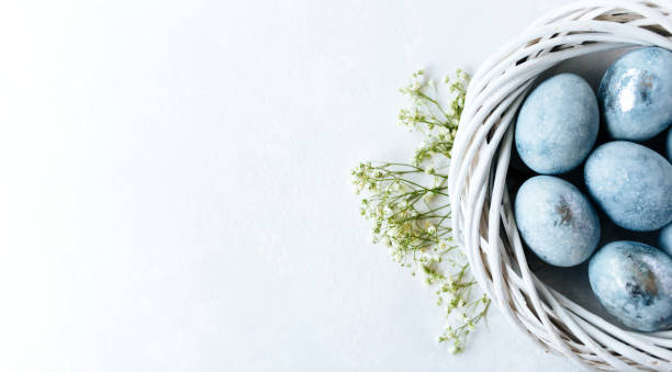 istock Blue ombre eggs on light background in the white nest. Spring flowers. Daylight. Stylish minimal Compositions in pastel colors. Easter concept. Flat lay, top view. Copy space 1208554781