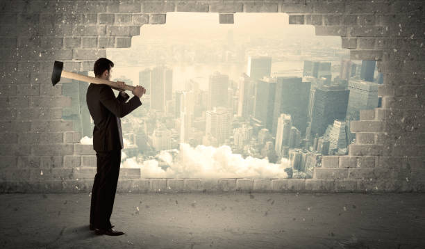 istock Business man hitting wall with hammer on city view 1208555146