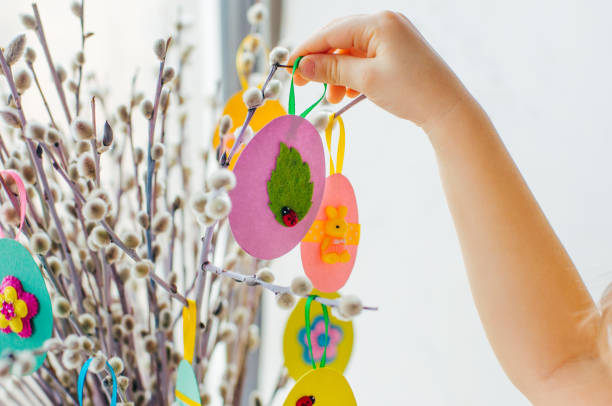 istock Easter eggs cutted from color paper decorated with ribbon and buttons on willow branches 1208557150