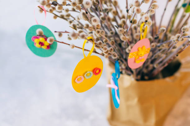 istock Easter eggs cutted from color paper decorated with ribbon and buttons on willow branches 1208557236