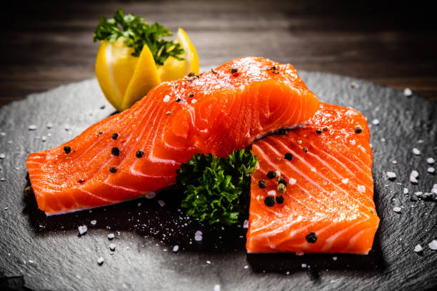 fresh raw salmon steak on cutting board - lemon food preparation portion imagens e fotografias de stock