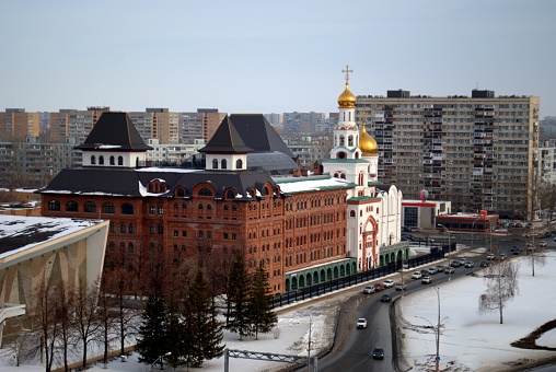 Evening view of the Volga Orthodox Institute and the Church of the Three Saints in the city of Tolyatti from the height of the 15th floor.