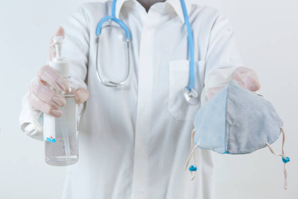 istock Doctor hands using washing hand with Alcohol Sanitizer and dust mask isolate on a white background. Promoting people use face mask to protect themselves from virus infection in  Corona virus crisis 2020 1208560363