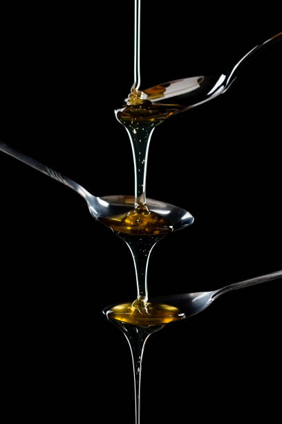 istock golden sweet honey dripping from spoon 1208562256