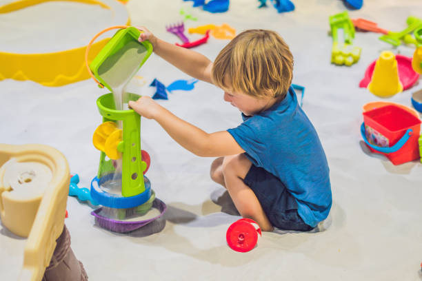 boy playing with sand in preschool. the development of fine motor concept. creativity game concept - sandbox child human hand sand imagens e fotografias de stock