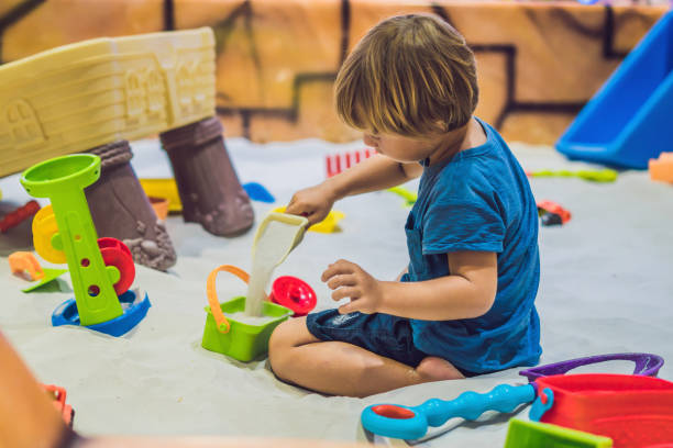 boy playing with sand in preschool. the development of fine motor concept. creativity game concept - sandbox child human hand sand imagens e fotografias de stock