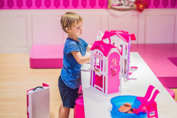 The boy plays with girl toys and dolls The boy plays with girl toys and dolls. doll photos stock pictures, royalty-free photos & images