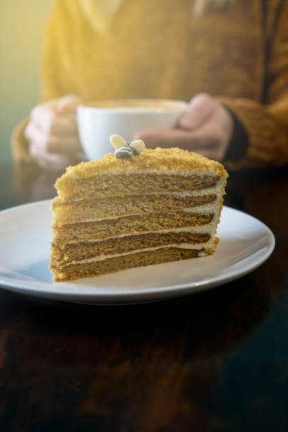 Cake, woman headless and hands with latte.