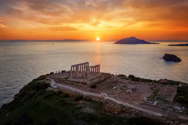 The historic Temple of Poseidon at Cape Sounion, Attica, Greece, during golden sunset time