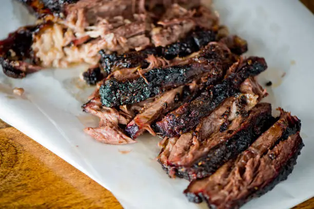 Photo of Beef Brisket barbecue Traditional Texas Smoke House . Rubbed with spiced & slow smoked in a classic Texas smoke house over mesquite wood chips in traditional classic bbq method. Chopped Beef Brisket.