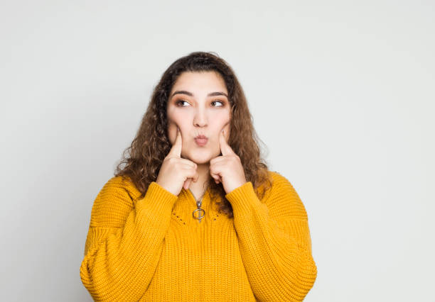 chica adolescente haciendo labios de pescado, tiro de estudio - chubby cheeks fotografías e imágenes de stock