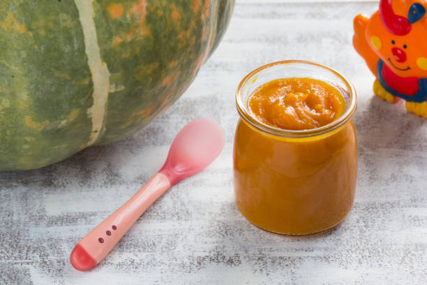 istock Pumpkin puree in glass jar and spoon on the white background 1208567752