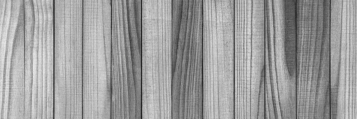 Worn, textured, black and white wooden timber board panoramic background. Very defined wood grain that can be used for a wood themed background.