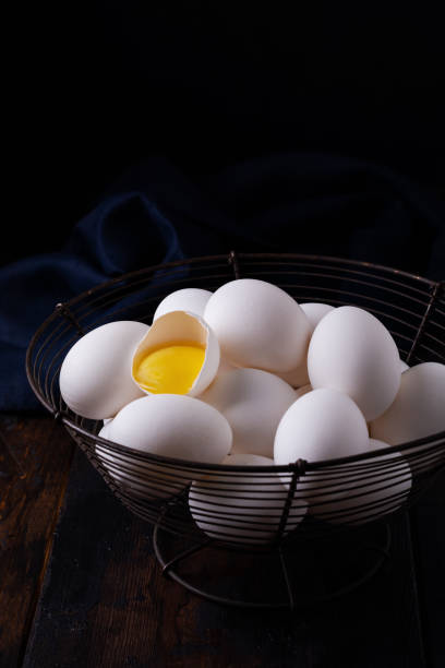 istock White raw chicken eggs in an old vintage basket on dark background. 1208569456