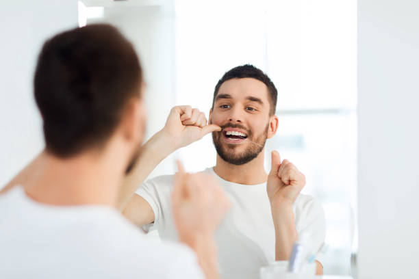 istock man with dental floss cleaning teeth at bathroom 1208570527