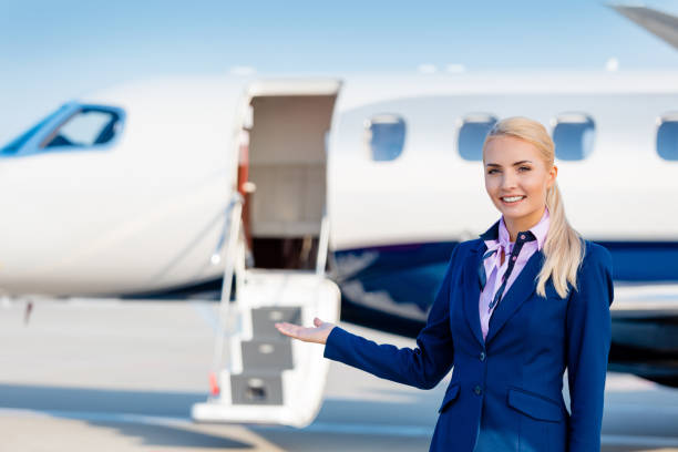 istock Beautiful air stewardess in front of private airplane 1208570622