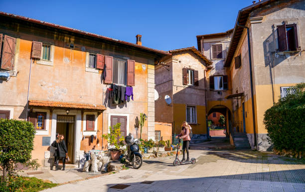 kobieta jeździ na elektrycznej hulajnodze w dzielnicy garbatella w dzielnicy ostiense w rzymie - balcony rome window ornate zdjęcia i obrazy z banku zdjęć